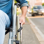Person in wheelchair beside road from RECOVER Injury Research Centre
