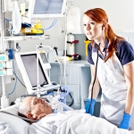 Doctor by patient in bed