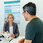 A physiotherapist discussing a leaflet of exercises with a patient