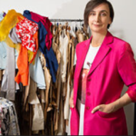 Person staning beside a rack of discarded clothes