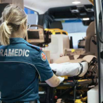 Paramedic pushing a trolley into an ambulance