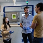Engineers collaborating at a Selective Laser Melting machine