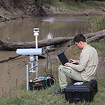Photo of a researcher monitoring methane emissions at a creek