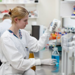 Person a laboratory bench holding an instrument